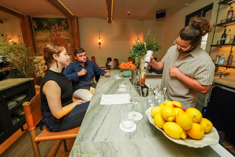 Benjamin Kirk, Beverage Director, mixes drinks for the Inquirer photographer, as friends of Bastia, a new restaurant inside Hotel Anna & Bel in Fishtown, gather during a photo session in the bar area on Monday, Aug. 5, 2024 in Philadelphia. Philadelphia, August 5,  2024.