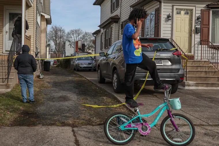A young boy practices his bike tricks behind the home on Lewis Avenue in East Landsdowne where a police shooting and fire took place is cleaned by crews on Feb. 8, 2024.  Six to eight people remain unaccounted for.