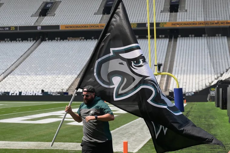 Eagles staffer Kevin di Girolamo, assistant to Swoop the mascot, practices flying the Eagles flag on Thursday, Sept. 5, 2024 at the Corinthians Arena in São Paulo, Brazil.