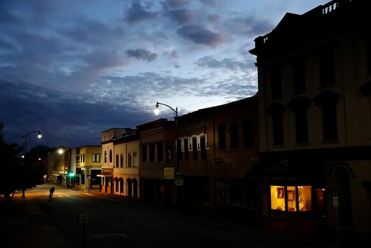 In this Oct. 28, 2017, file photo, the storefront window of a portrait studio is lit up along a downtown street at dusk in Lumberton, N.C. With a little over one month to go in 2019, small business owners should think about purchases or investments that make good business sense and will give them a break on their taxes. (AP Photo/David Goldman, File)