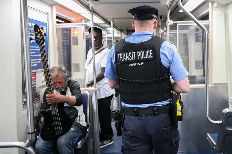 A SEPTA police officer walks along the El train as it departs 13th street station in Philadelphia on Wednesday, May 31, 2023.