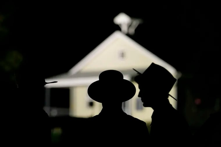 Amish men are seen in front of the schoolhouse where a gunman killed several people and injured others in Nickel Mines, Pa., on Oct. 2, 2006. Eighteen years later, shooting survivor Rosanna King has died.