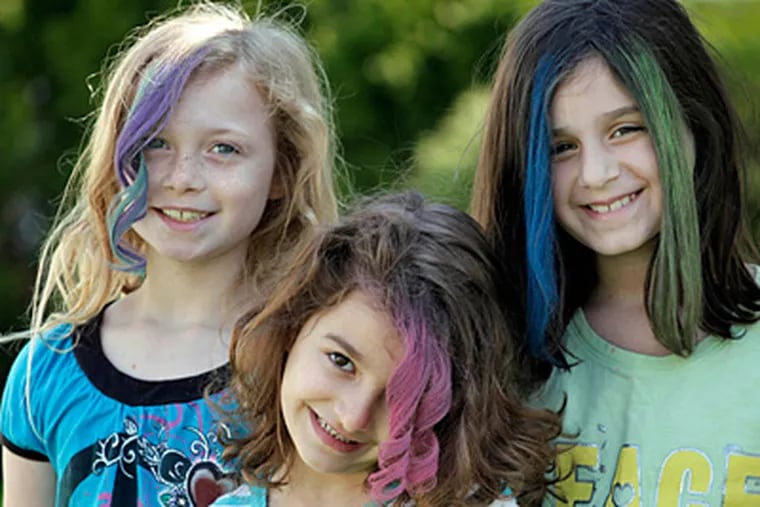 Maddie Parizek, Sadie Moussa, and Gabriella Lujan, left to right, show off their hairstyles created with soft pastel chalk applied by neighborhood mom Orly Telisman in Chicago. Everyone from hipsters to children to Hollywood celebrities is embracing the runway fad for brightly colored hair, using soft pastel chalk.  (AP Photo/M. Spencer Green)