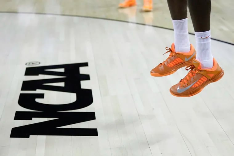 In this March 21, 2013, file photo, an athlete jumps near the NCAA logo during practice for a second-round game of the NCAA college basketball tournament in Austin, Texas. California's governor signed a first-in-the-nation law Monday, Sept. 30 to let college athletes make money from endorsements, defying the NCAA — who then turned around last week and changed their policy.