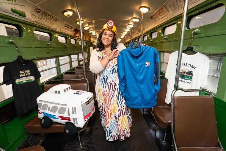 Al'Lee Floyd, manager of the SEPTA Store and experiential design, poses with SEPTA merchandise inside of a PCC Trolley at the transit agency's Center City headquarters. Yes, even the hard hat is SEPTA-branded.