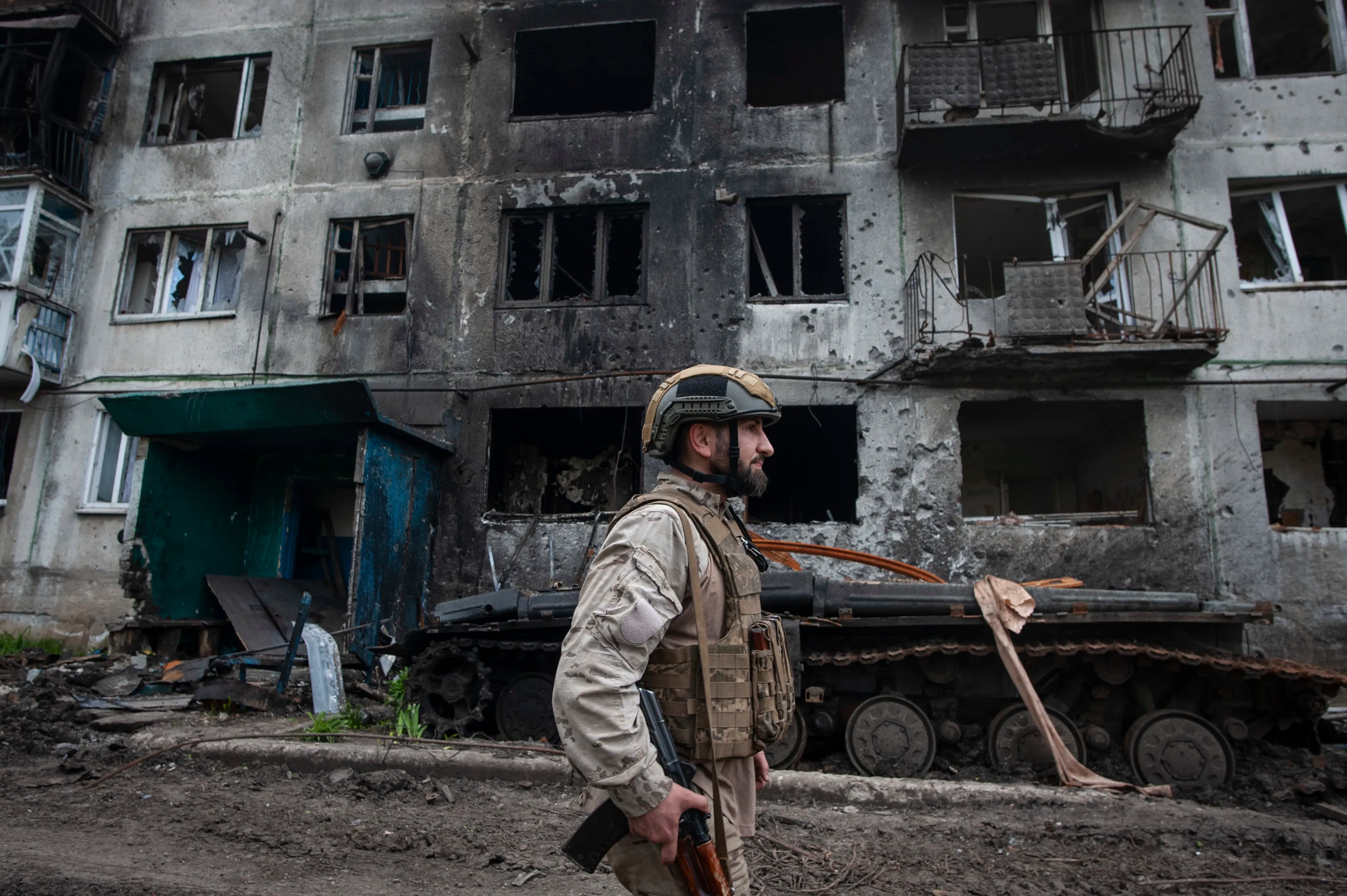 A Ukrainian soldier passes by a damaged apartment building in Chasiv Yar, the site of heavy battles with the Russian forces in the Donetsk region, Ukraine.