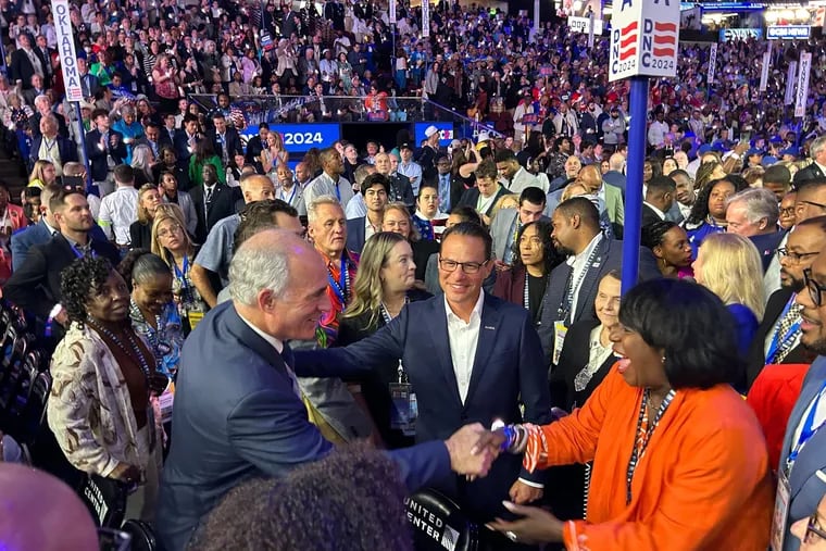 Philadelphia Mayor Cherelle L. Parker, right, greets U.S. Sen. Bob Casey (D., Pa.), left, on the floor of the Democratic National Convention as Pennsylvania Gov. Josh Shapiro, center, looks on.