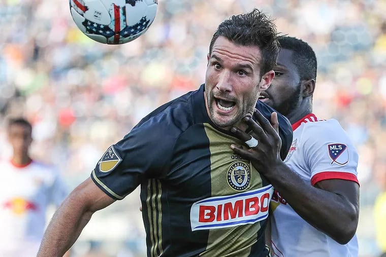 Union forward Chris Pontius keeps his eye on the ball with New York Red Bulls defender Kemar Lawrence.
