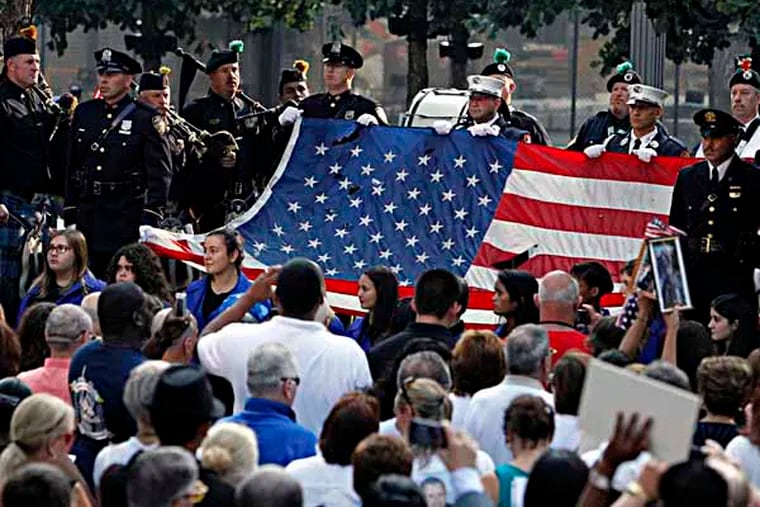 The World Trade Center Flag is presented as friends and relatives of the victims of the 9/11 terrorist attacks gather at the National September 11 Memorial at the World Trade Center site, Wednesday, Sept. 11, 2013, for a ceremony marking the 12th anniversary of the attacks in New York. (AP Photo/Jason DeCrow)