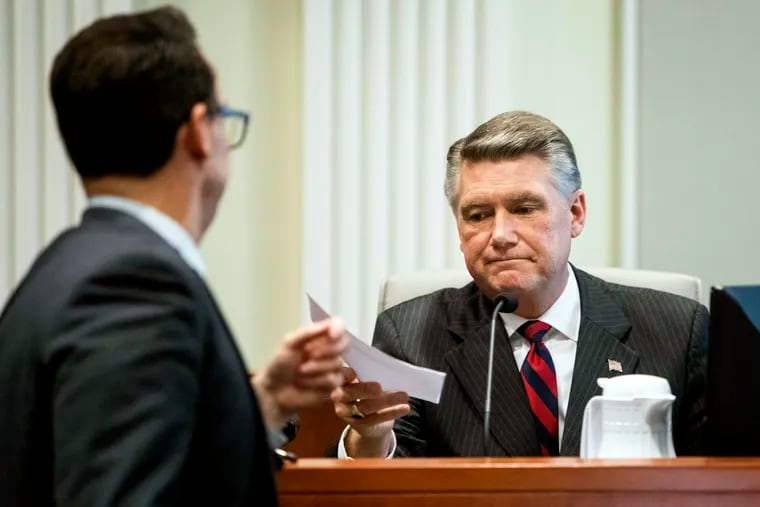 Josh Lawson, chief counsel for the state Board of Elections and Ethics Enforcement, left, hands Mark Harris, Republican candidate in North Carolina's 9th congressional race, a document during the fourth day of a public evidentiary hearing on the 9th congressional district voting irregularities investigation Thursday, Feb. 21, 2019, at the North Carolina State Bar in Raleigh, N.C.