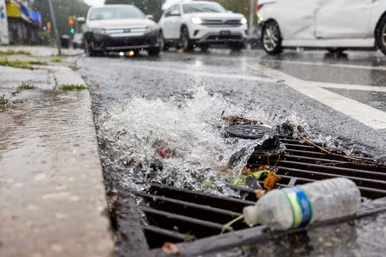 Water rushing into a drain as rain begins to pour down along Wayne Avenue in Germantown on Aug. 9 when Debby-related downpours visited the region.