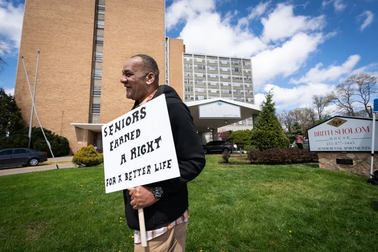 A protester carrying a sign to publicize the living conditions at Brith Sholom House apartments in April.