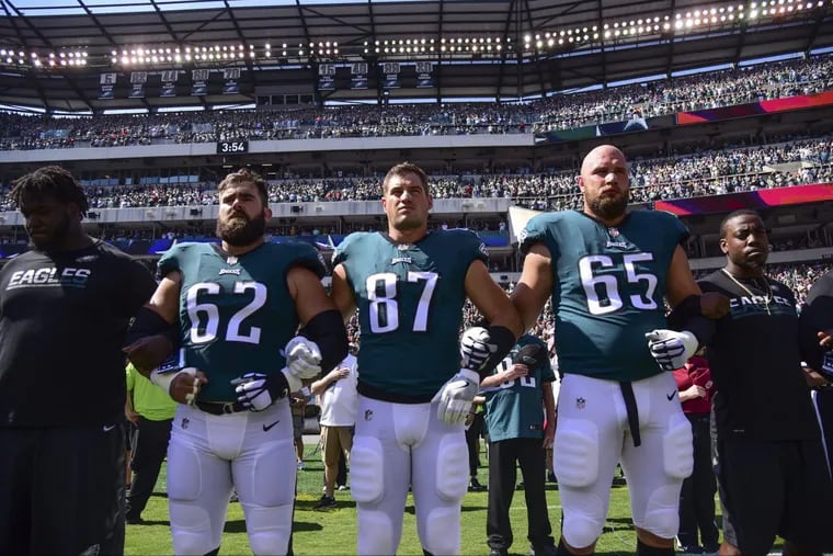 Eagles players Jason Kelce (left), Brent Celek and Lane Johnson hook arms during the playing of the national anthem before the game against the Giants at Lincoln Financial Field Sept. 24, 2017. The Eagles won, 27-24.
