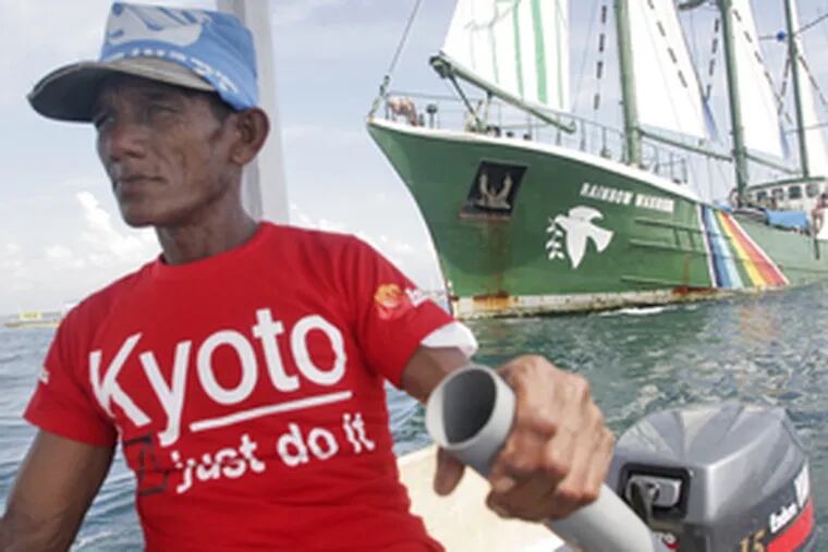 A fisherman in Bali escorts Greenpeace&#0039;s Rainbow Warrior ship on its arrival in Indonesia as the climate conference begins. The group is calling on leaders at the talks to negotiate the next round of the Kyoto Protocol.