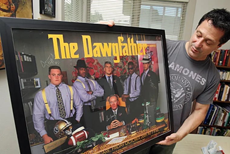 In his Seattle, Washington home on July 13, 2011, John Costacos holds one of the posters he created with his brother of UW football coach Don James with his linemen. The brothers&apos; posters have become almost as legendary as the sports icons they feature. (Ken Lambert/Seattle Times/MCT)
