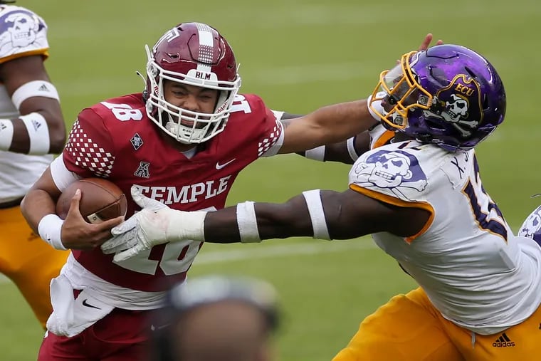 Temple quarterback Kamal Gray (18) tries to fend off East Carolina inside linebacker Xavier Smith (12) during Saturday's game.