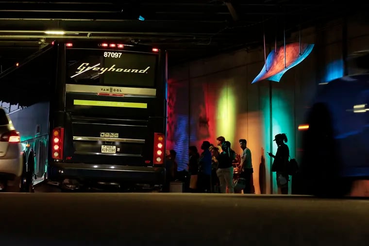 Travelers wait to board a Greyhound bus under the 95 overpass on Spring Garden Street.