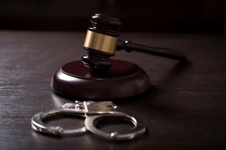 Close up of a judge gavel and handcuffs in a courtroom. 