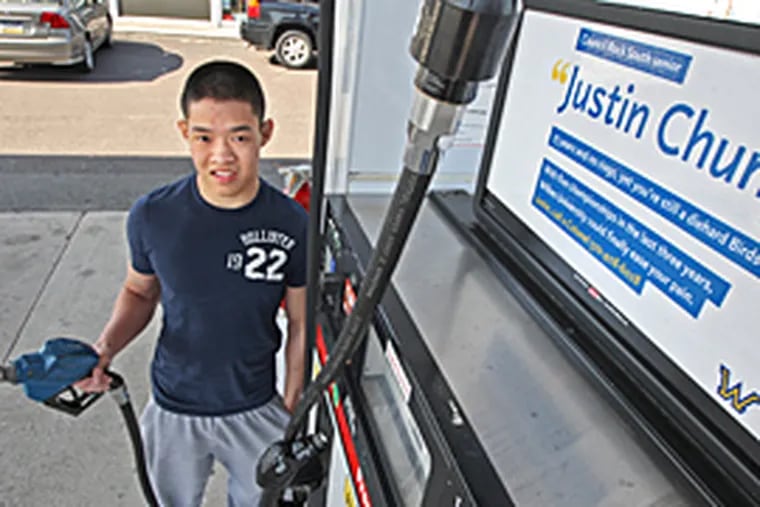 "It's like I'm famous," says Justin Chung, at a Penndel pump with a Wilkes ad featuring him. (Michael Bryant/Inquirer)