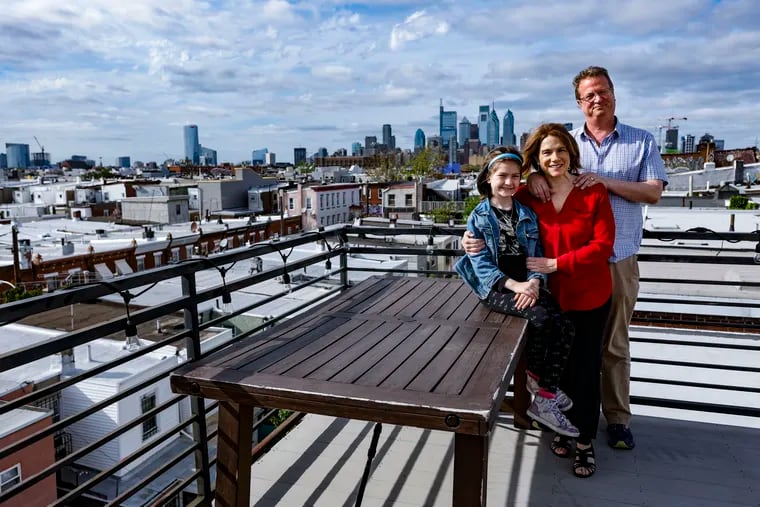 Melanie Julian and Lane Savadove, with 9-year-old daughter Emmeline, live in a three-story stand-alone brownstone built in 1893. Here, they pose on their rooftop deck.