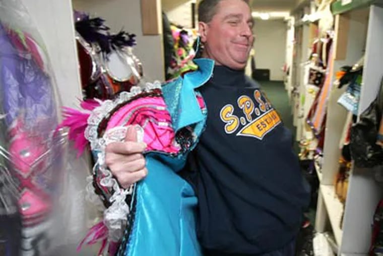 South Philly Mummer Harry Dougherty, 51, shows how hard it is to disrobe from a costume if nature calls on Broad Street. (David Swanson / Staff Photographer)