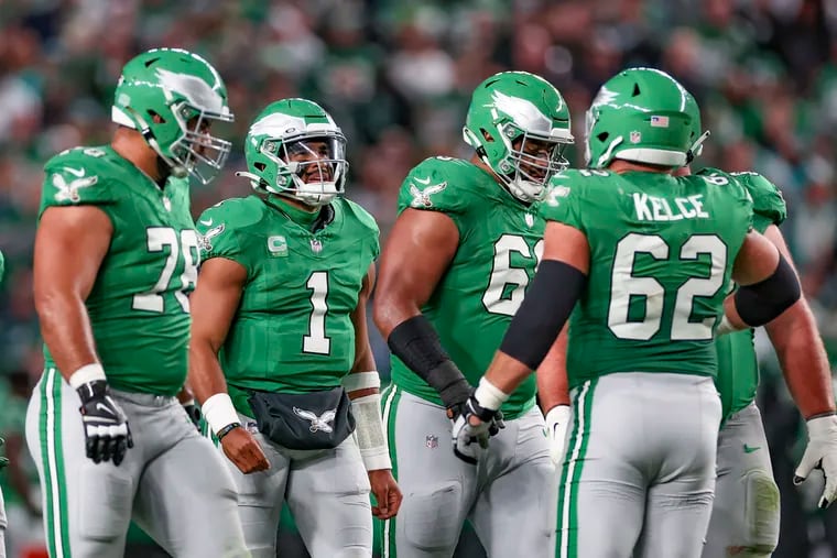 Eagles quarterback Jalen Hurts huddles with his offensive line during their win over the Miami Dolphins. The Eagles will wear their kelly green jersey for the second time on Sunday.