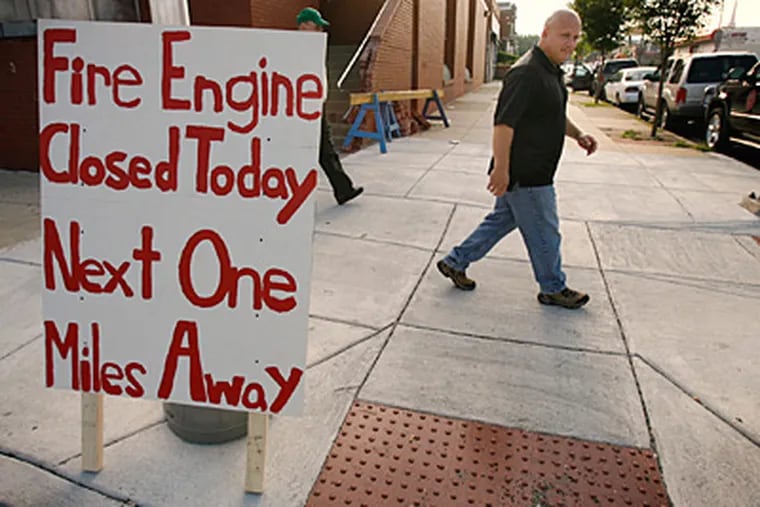 Jack Eltman, public relations director for the Philadelphia Fire Fighters Union, Local N. 22, and the sign he placed at Engine 57, at the corner of 56th and Chestnut. (Alejandro A. Alvarez/Staff)