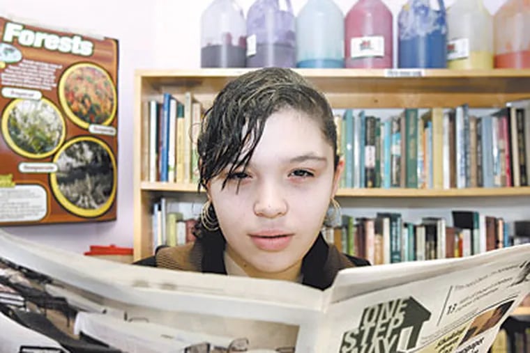 Thirteen-year-old Stephanie Bermudez holds a copy of One Step Away in the library of  Woodstock Shelter in North Philadelphia. ( Bonnie Weller / Staff Photographer )