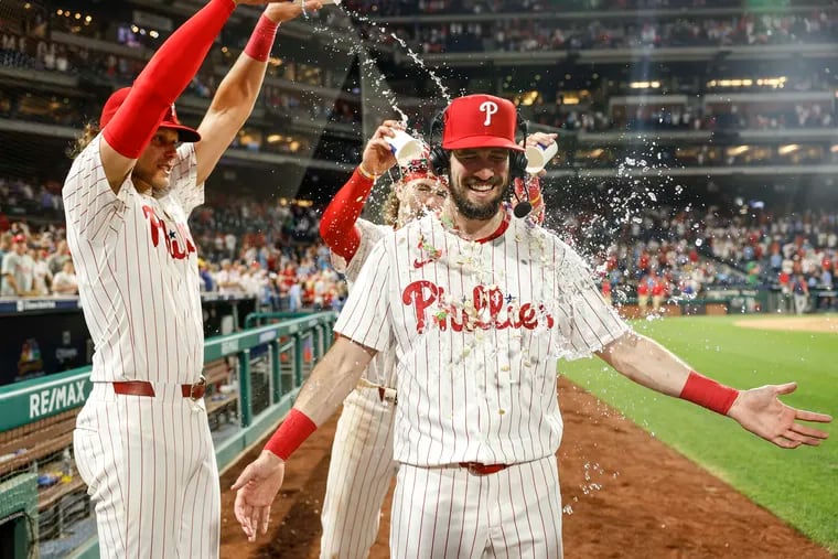 Phillies David Dahl gets a water bath from teammates Alec Bohm left and Bryson Stott after beating the Brewers 3-1 at Citizens Bank Park in Philadelphia, Monday, June 3, 2024
