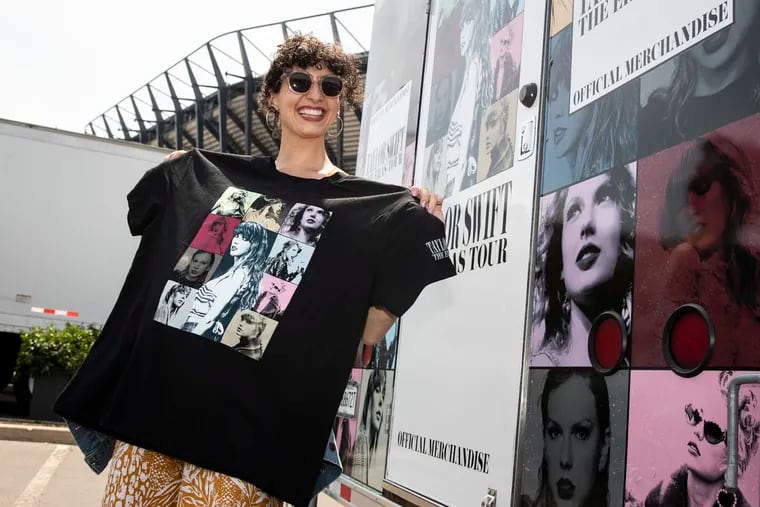 Elizabeth Estrada, 32, shows off some of the merchandise she purchased in Lot K for Taylor Swift's "Eras Tour" a day before the concert at Lincoln Financial Field in Philadelphia on Thursday, May 11, 2023.