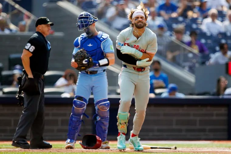 Phillies first baseman Bryce Harper holds his arm after being hit by a pitch in the first inning against the Toronto Blue Jays.