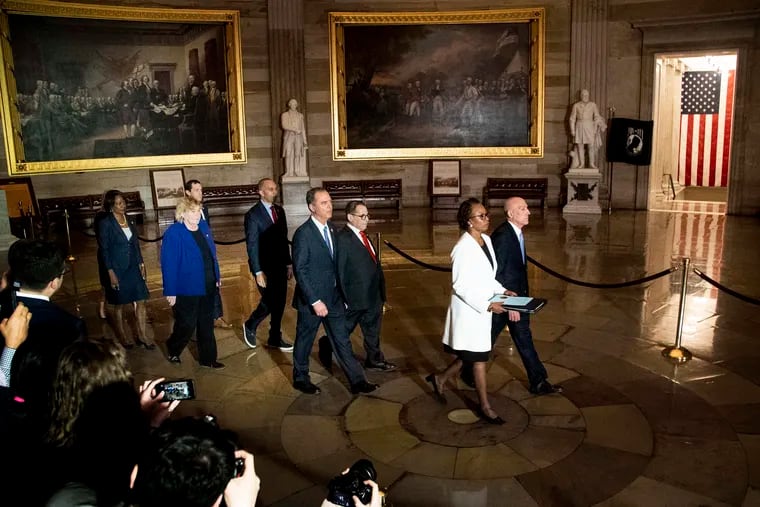 Leading the way to deliver the articles of impeachment to the Senate are Paul Irving (right), House sergeant at arms, and Cheryl Johnson,clerk of the House. Behind them, in a solemn procession, are the designated impeachment managers.