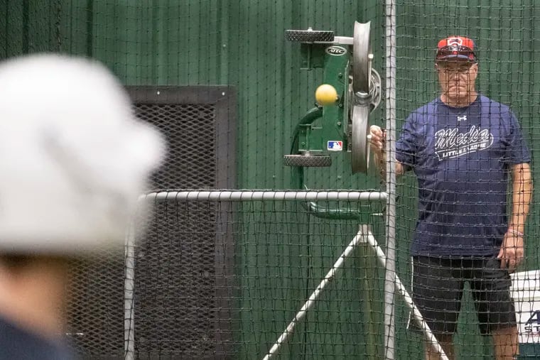 Media Little League manager Tom Bradley mans the pitching machine as the Delco team practices Tuesday in South Williamsport, Pa.
