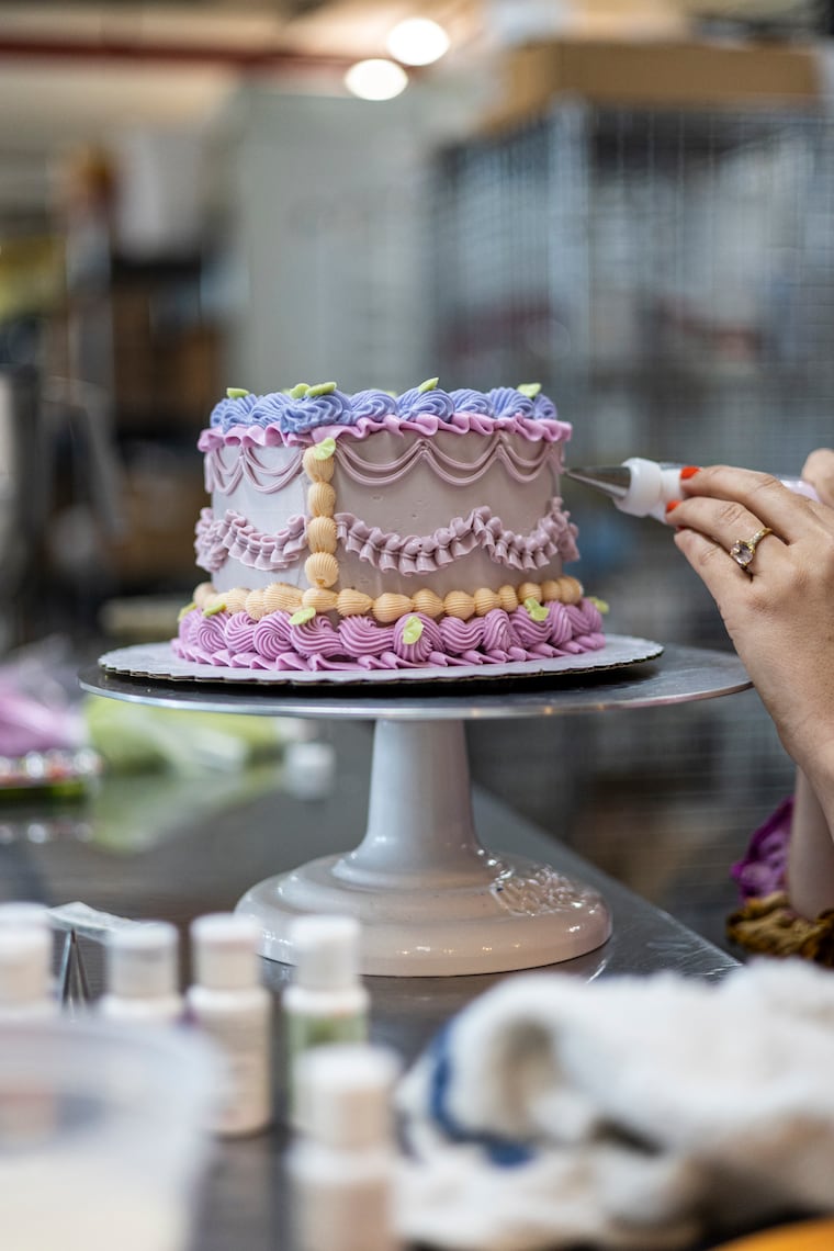 New June owner Noelle Wheatley Blizzard adds colorful, detailed patterns of buttercream on a cake order on Thursday, June 23, 2023, in Philadelphia, Pa.