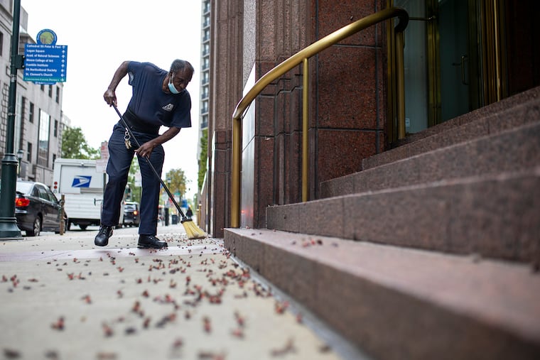 George Thompson, 65, of North Philadelphia, custodian and housekeeper for Allan Industries, is killing and sweeping up dead spotted lanternflies on the sidewalk along 18th and Arch Streets in  September 2020. 