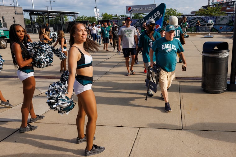 Eagles cheerleaders greet fans arriving to buy new kelly green team merchandise. Philadelphia Eagles fans gathered outside the Lincoln Financial Field and Pro Shop to buy Eagles kelly green merchandise on Monday morning July 31, 2023.