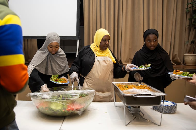 (left to right) Yasmine Talonto, 14, Kaliema Ali, and Saaniyah Washington 10, serve the iftar meal of fish fried rice and salad at Masjidullah in Philadelphia on Tuesday, March 12, 2024. Ramadan is observed by Muslims with a month of fasting. The fast is broken each day with a nightly meal called iftar.