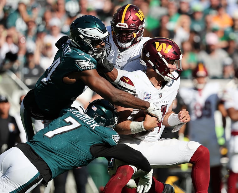 Eagles linebacker Haason Reddick sacks Washington Commanders quarterback Sam Howell with defensive end Josh Sweat in the fourth quarter on Sunday, October 1, 2023 in Philadelphia.