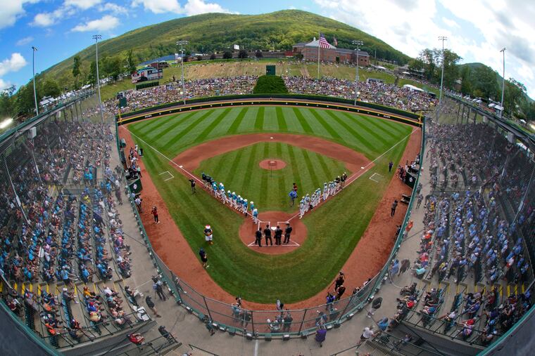 The El Segundo, Calif., team lines the first base line and the Curacao team lines the third base line during introductions before the 2023 Little League World Series championship.