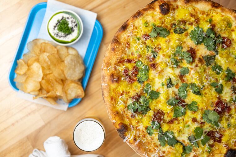 The samosa pizza with a side of 12-hour onion dip and chips at Carbon Copy in West Philadelphia.