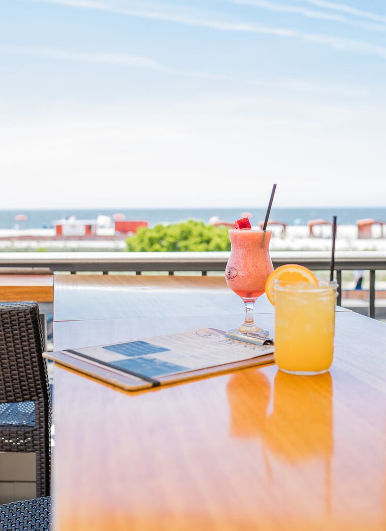 Refreshing cocktails at a table with a view of the ocean at Harry's Ocean Bar & Grille in Cape May, NJ.