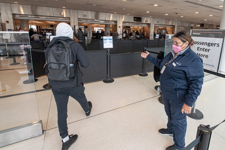 A traveler going through a TSA security checkpoint at Philadelphia International Airport in 2021.