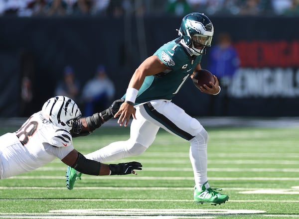 Eagles quarterback Jalen Hurts runs with the ball past Bengals defensive tackle Sheldon Rankins in the fourth quarter at Paycor Stadium.