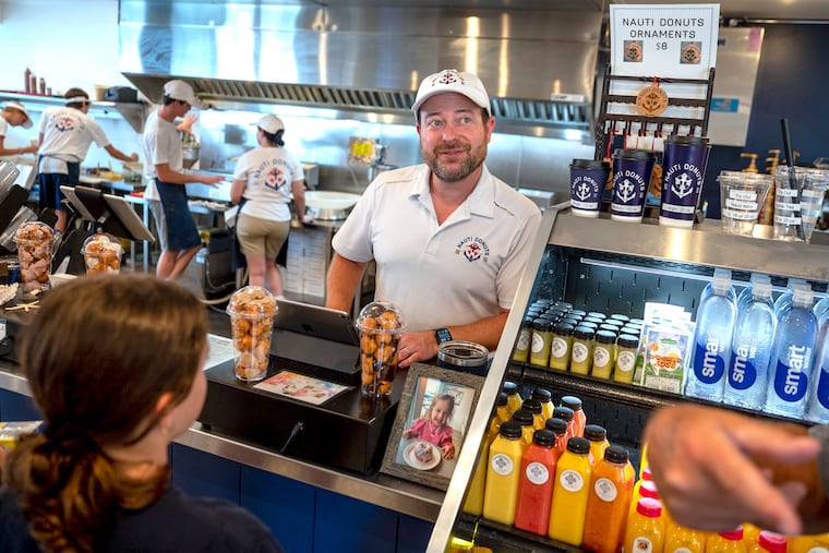 Owner Chris O’Hara talks with customers at Nauti Donuts in Ocean City, Monday, July 24, 2023.