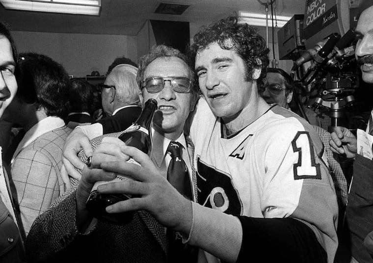 Flyers coach Fred Shero and defenseman Joe Watson share a bottle of champagne after the team won the 1974 Stanley Cup by beating the Boston Bruins.