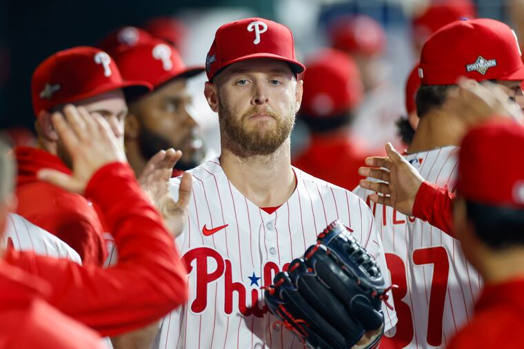 Phillies ace Zack Wheeler is greeted by teammates in the dugout.