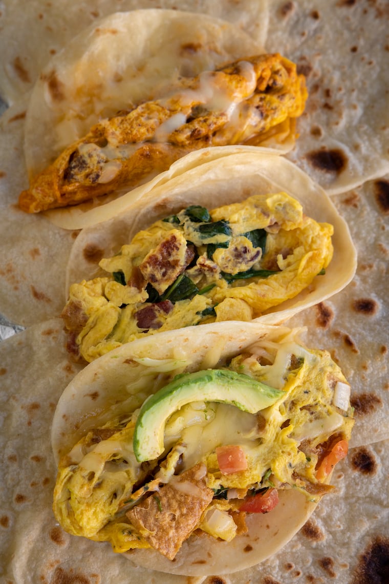 Three Taco Heart breakfast tacos before they're rolled in foil: Migas, The 4th Street, and Chorizo Egg and Cheese.