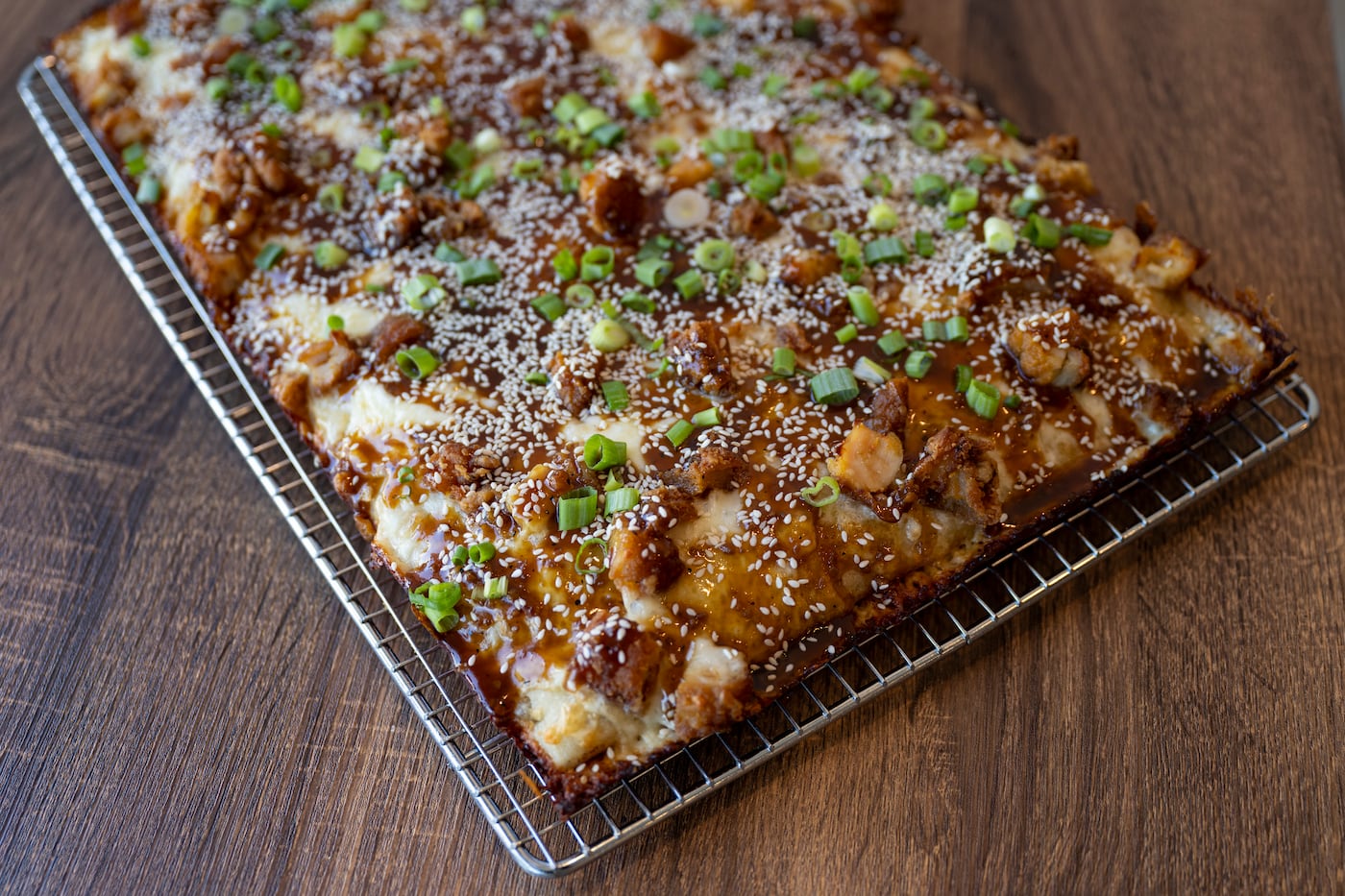 The K-pop at Bakeria 1010, a white pie topped with chicken, sesame seeds, scallions, and a sweet Korean barbecue sauce.