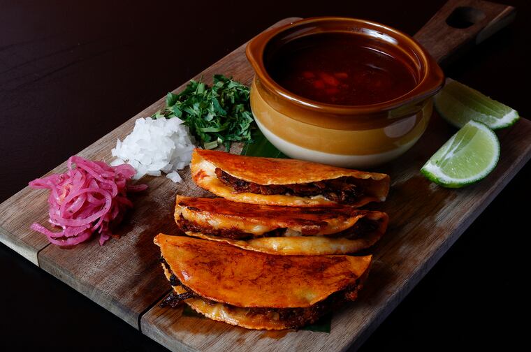 The quesabirria tacos with braised lamb in adobo, onions, cilantro chihuahua cheese and consomme served at Tamalex Bar & Grill in the Society Hill neighborhood of Philadelphia on Friday, February 8, 2024.