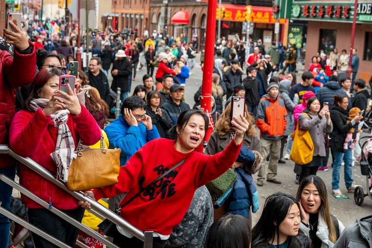 Spectators photograph as the Year of the Dragon kicks off in Chinatown Sunday, Feb. 11, 2024 with the annual Lunar New Year’s Day Parade. The Philly Suns lion dance group lead the way through with dancing, drumming, music, and firecrackers, as part of a cultural celebration to bring good fortune and good luck to the local businesses in the community.